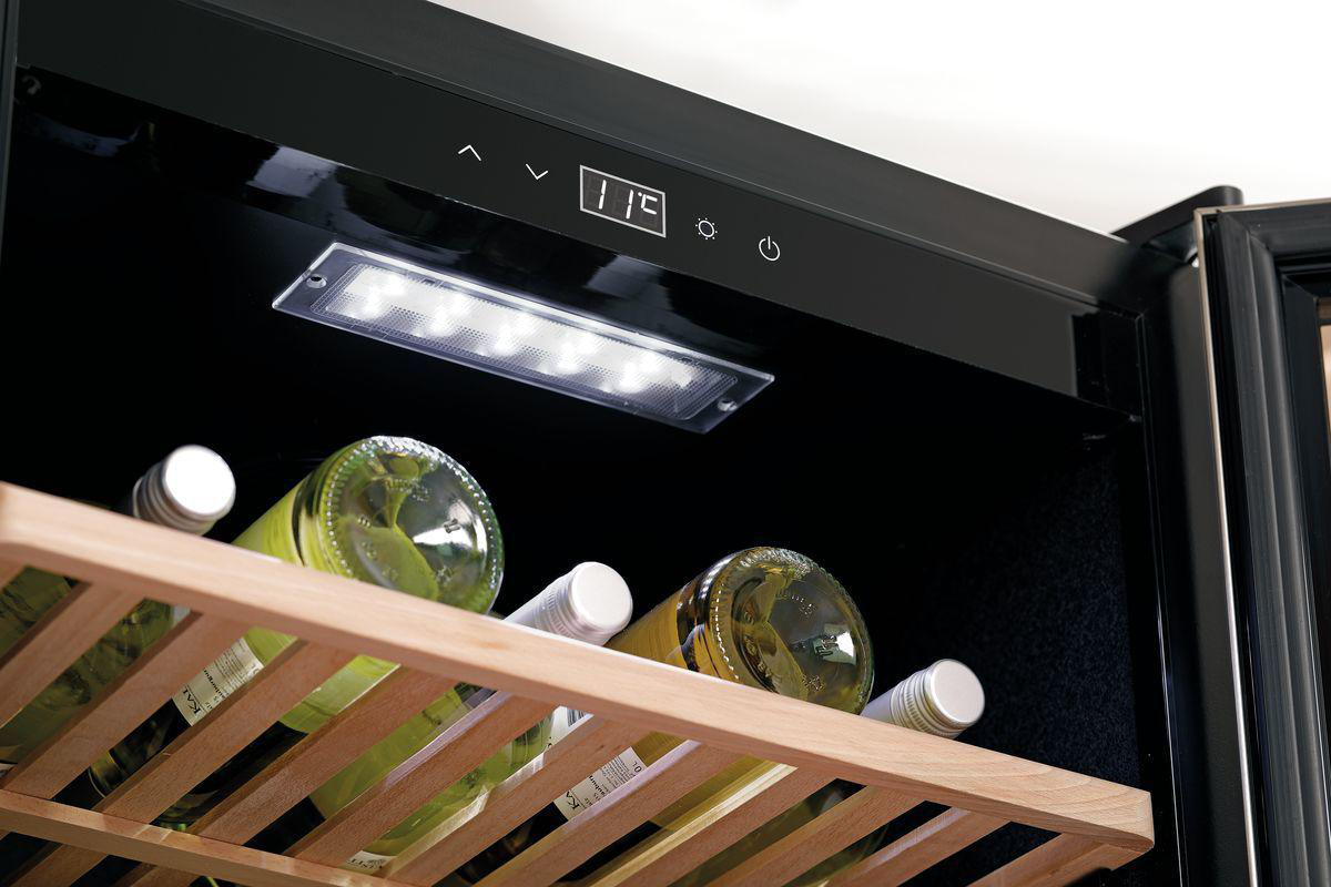 In einem Weinkühlschrank stehen Flaschen auf Holzregalen. Lichter beleuchten die Flaschen. Eine Digitalanzeige zeigt die Temperatur.