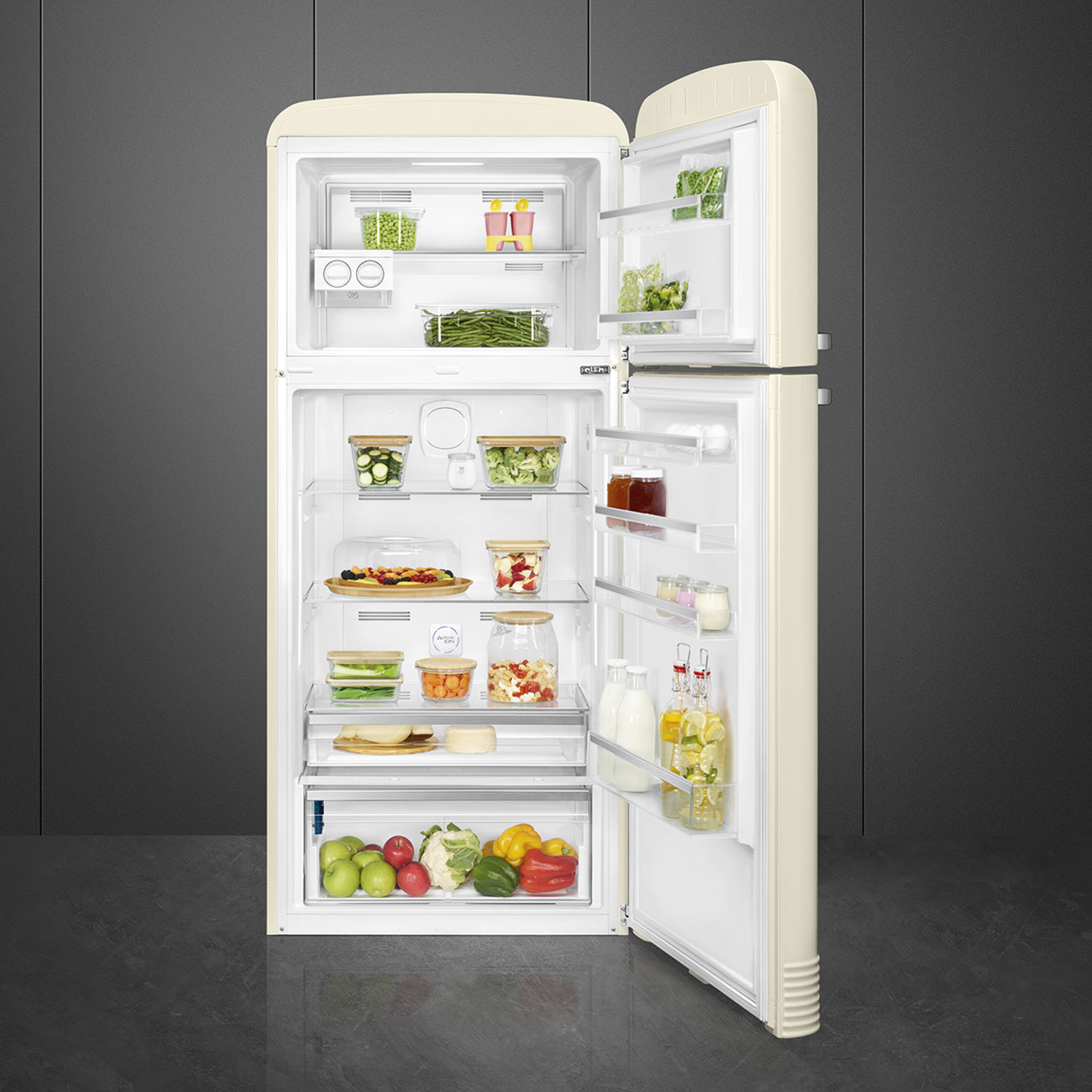 Frigorifero Smeg color crema, aperto, che mostra ripiani di cibo. Il frigorifero è su un pavimento grigio.