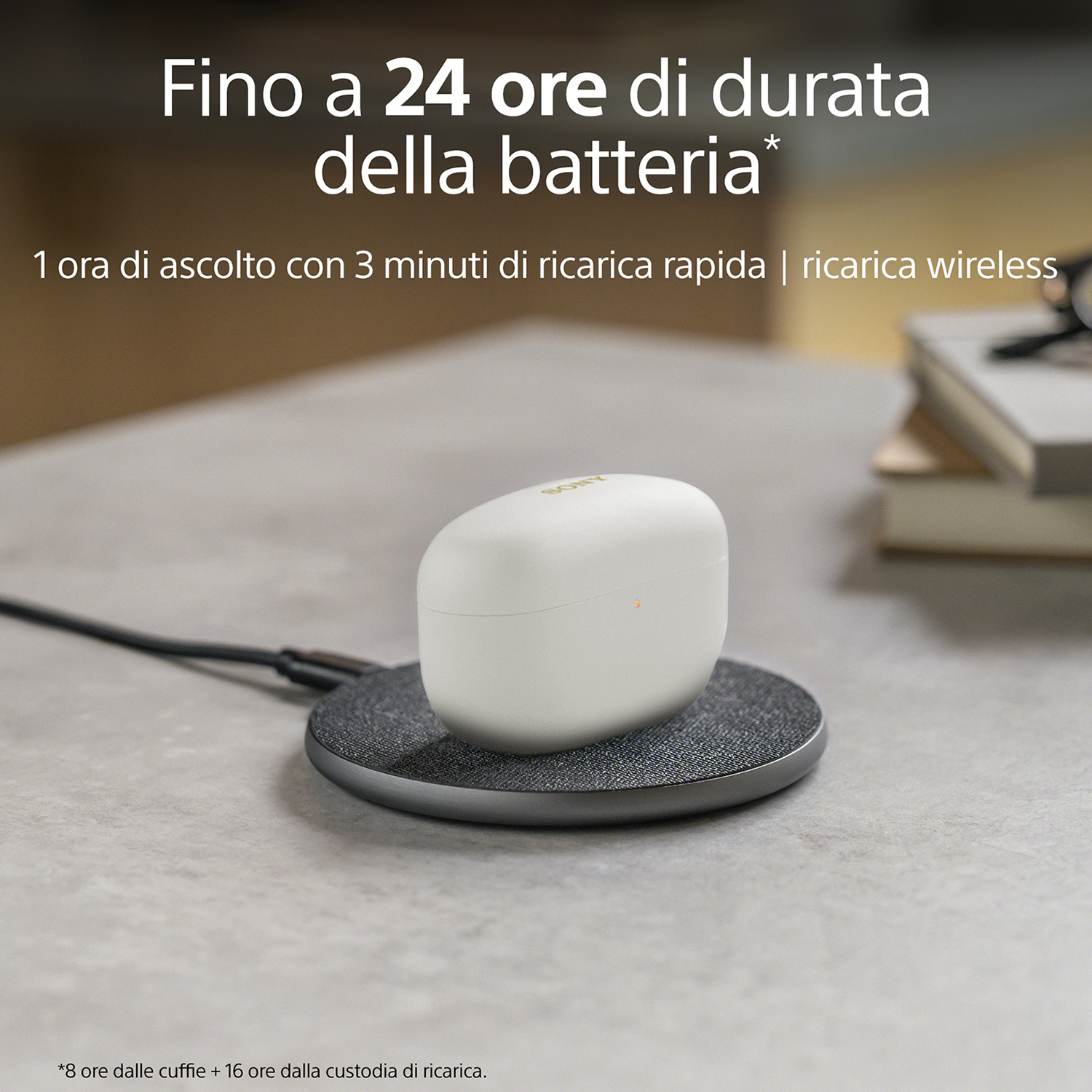 Auricolari in carica su un pad di ricarica, testo sopra: 24 ore di durata della batteria.