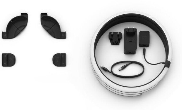 Białe, okrągłe urządzenie z kilkoma czarnymi elementami w środku. Różne wtyczki i ładowarki.