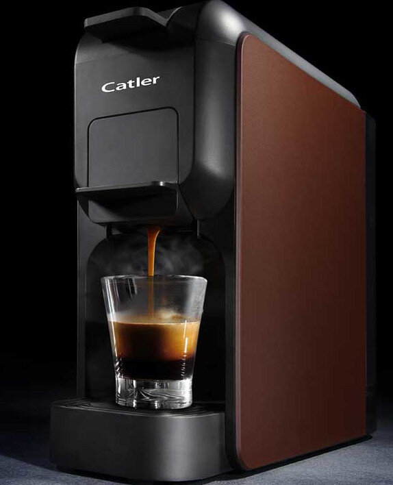 Ekspres do kawy z brązowym panelem bocznym. Espresso nalewa się do szklanki.