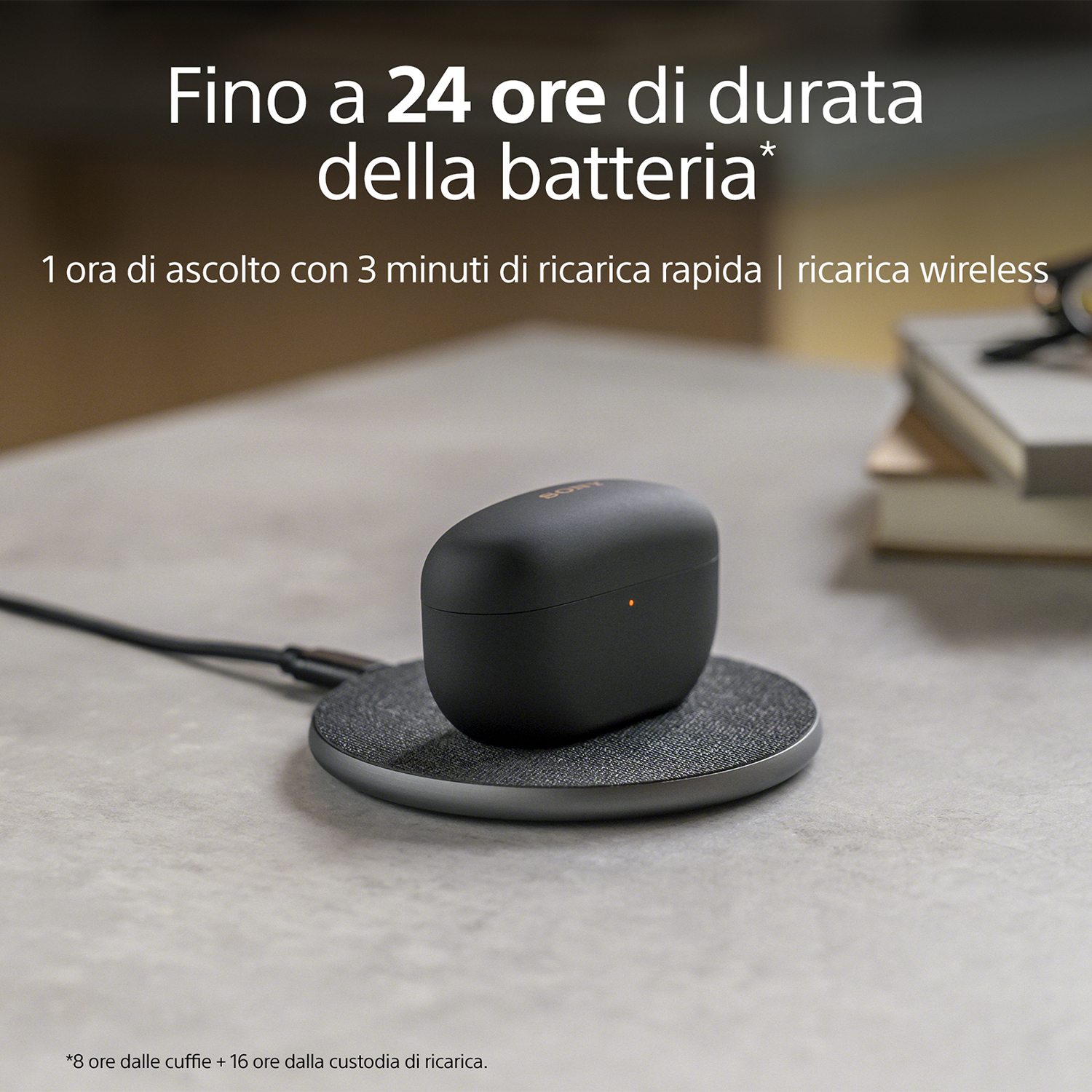 Custodia di ricarica nera con auricolari su un tappetino di ricarica. Testo sulla durata della batteria in alto.