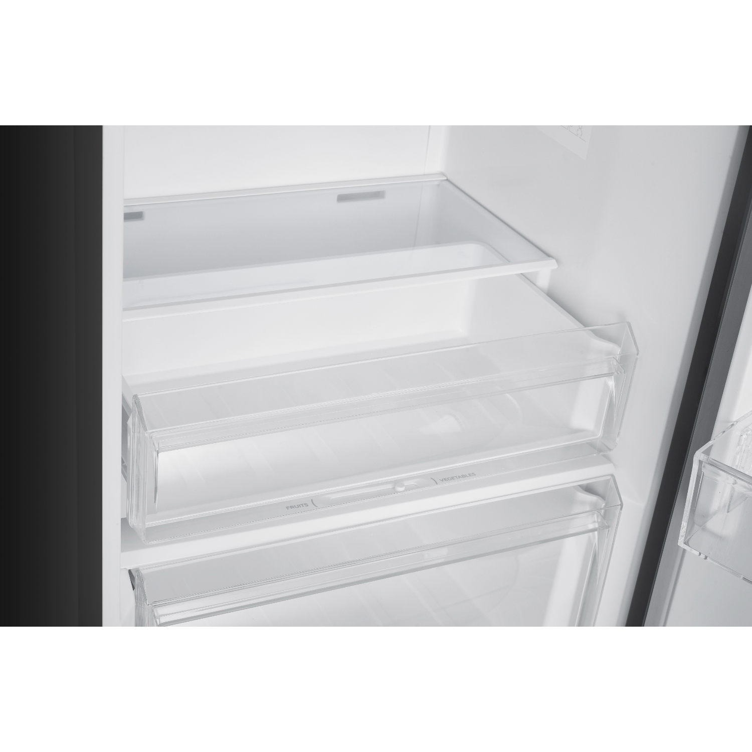 Inside of a refrigerator with clear drawers labeled fruits and vegetables.