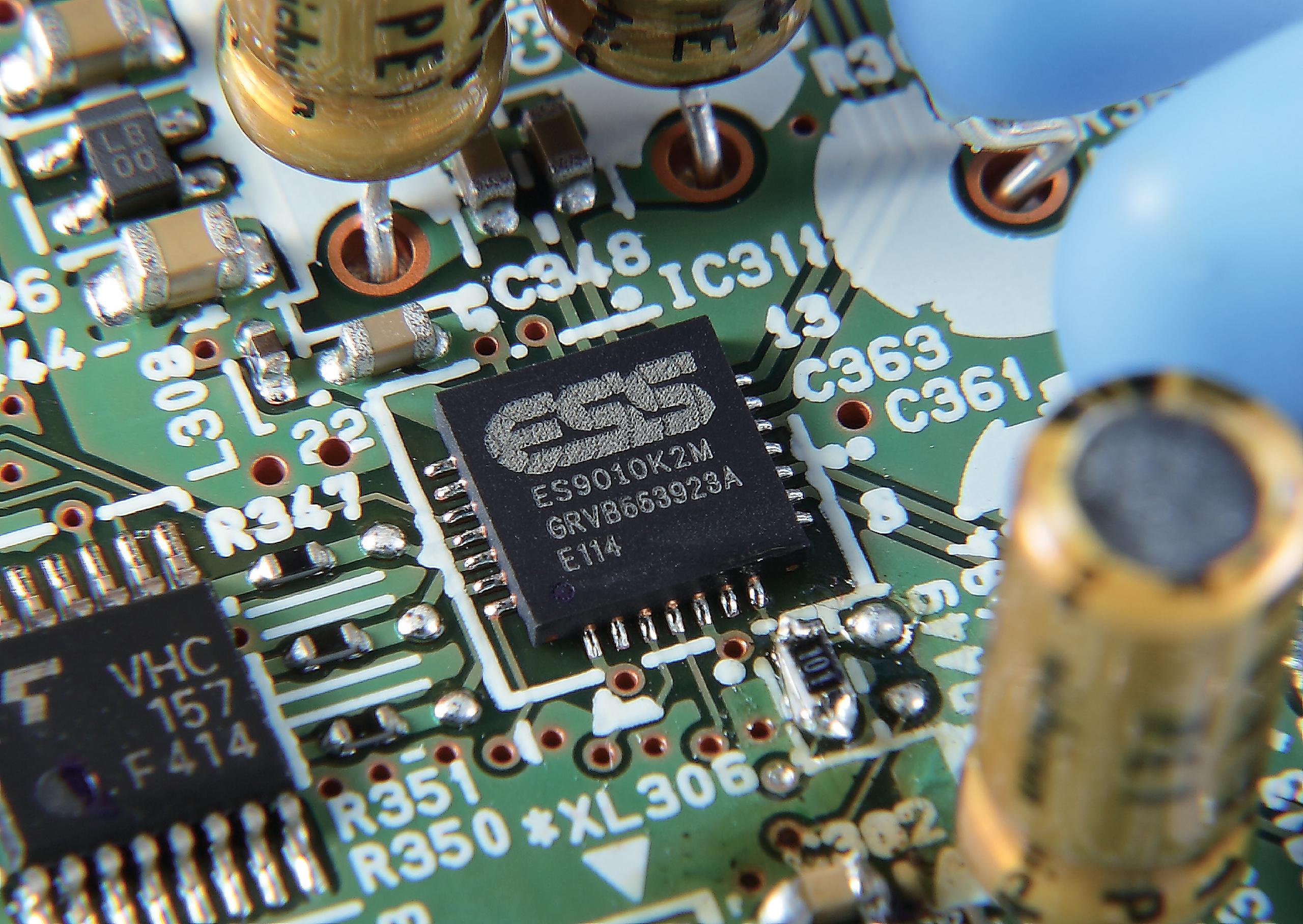 Eine Leiterplatte mit einem schwarzen Chip in der Mitte. Der Hintergrund ist unscharf.