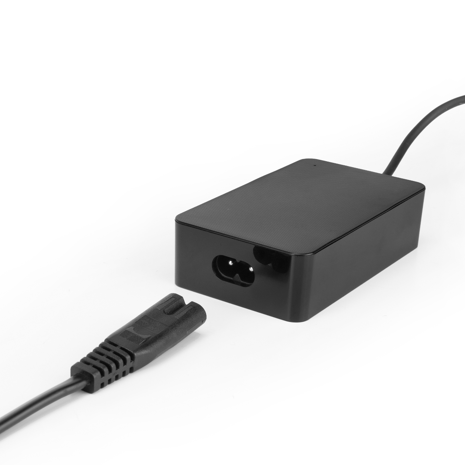 Zwarte voedingsadapter met stekker en losgekoppelde connector op een witte ondergrond.