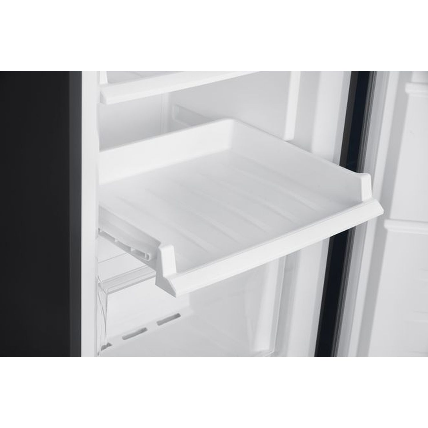 Intérieur de réfrigérateur blanc avec une étagère blanche, détail.