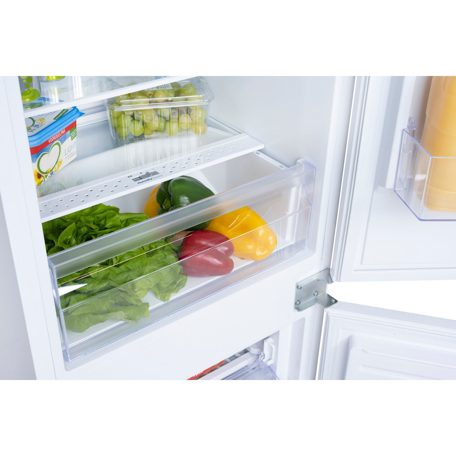 Open refrigerator with vegetables, butter, and juice visible.