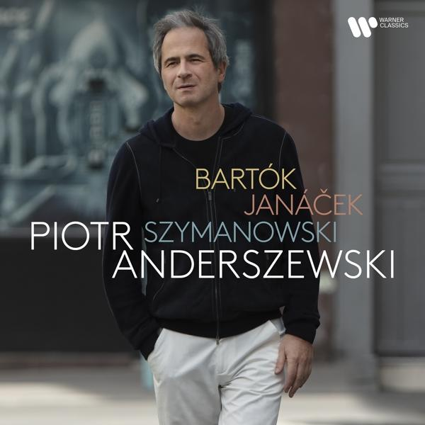 Pianist Piotr Anderszewski geht nach draußen und trägt einen schwarzen Hoodie und weiße Hosen.