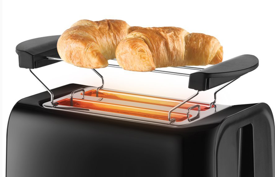 Fekete kenyérpirító két croissant-val a melegítőállványon, fehér háttérrel.