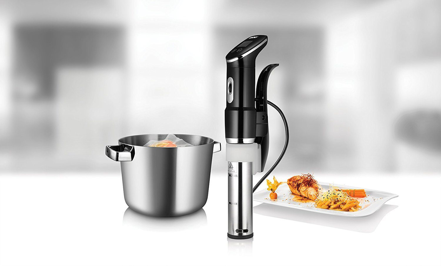 Sous vide merülő keringető egy edénnyel és étellel a tányéron. Fehér háttér.