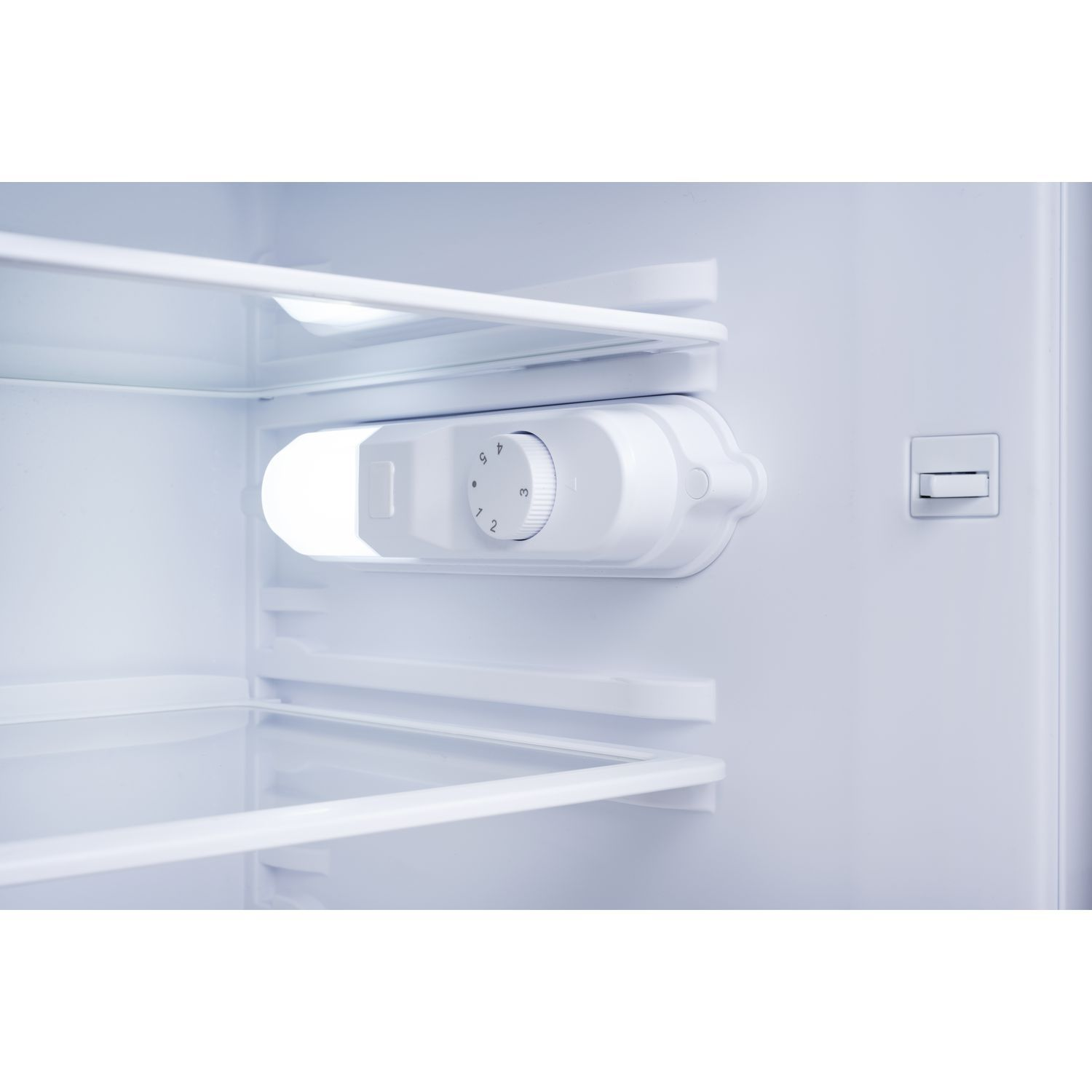 Intérieur d'un réfrigérateur blanc avec étagères et contrôle de la température.
