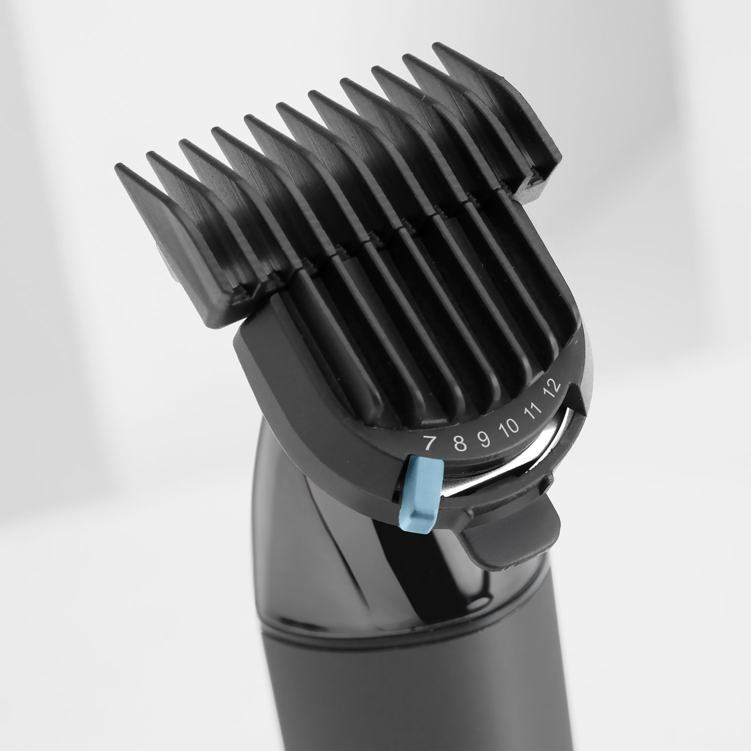 Black hair clipper attachment with adjustable settings, on a light background.
