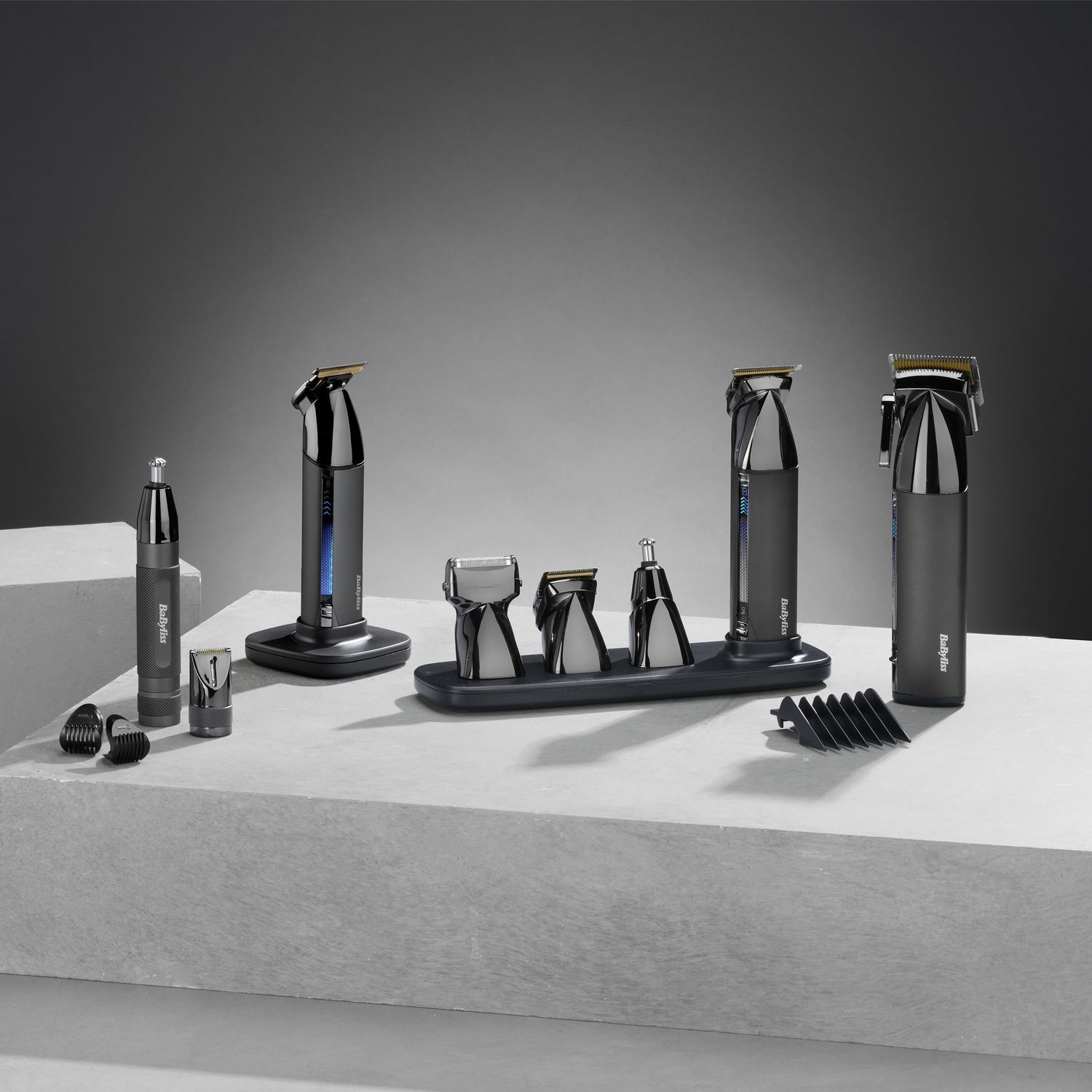 Various silver and black grooming devices and accessories, arranged on a white surface.