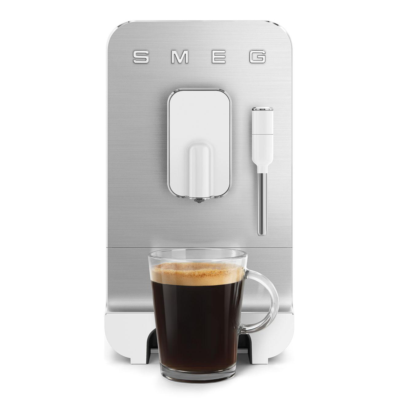 Silberne Smeg Kaffeemaschine mit einem Glas schwarzen Kaffees. Weißer Hintergrund.
