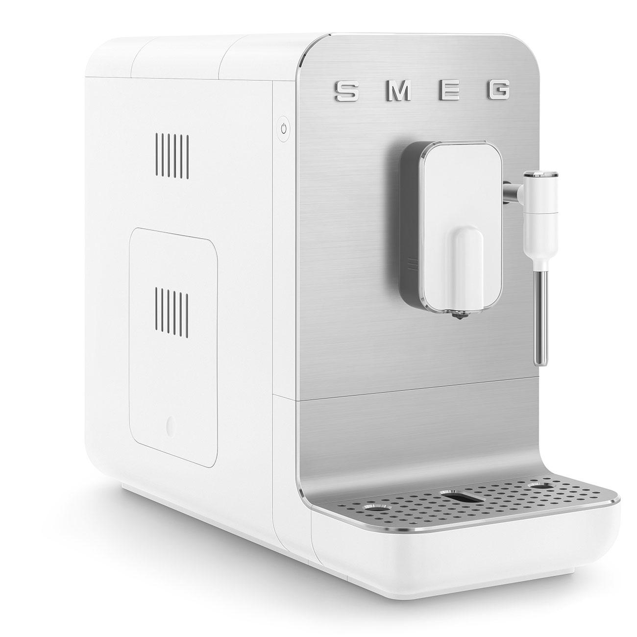 Weiß-silberne SMEG Kaffeemaschine mit Ausguss und kleinem Fach, auf weißer Oberfläche.