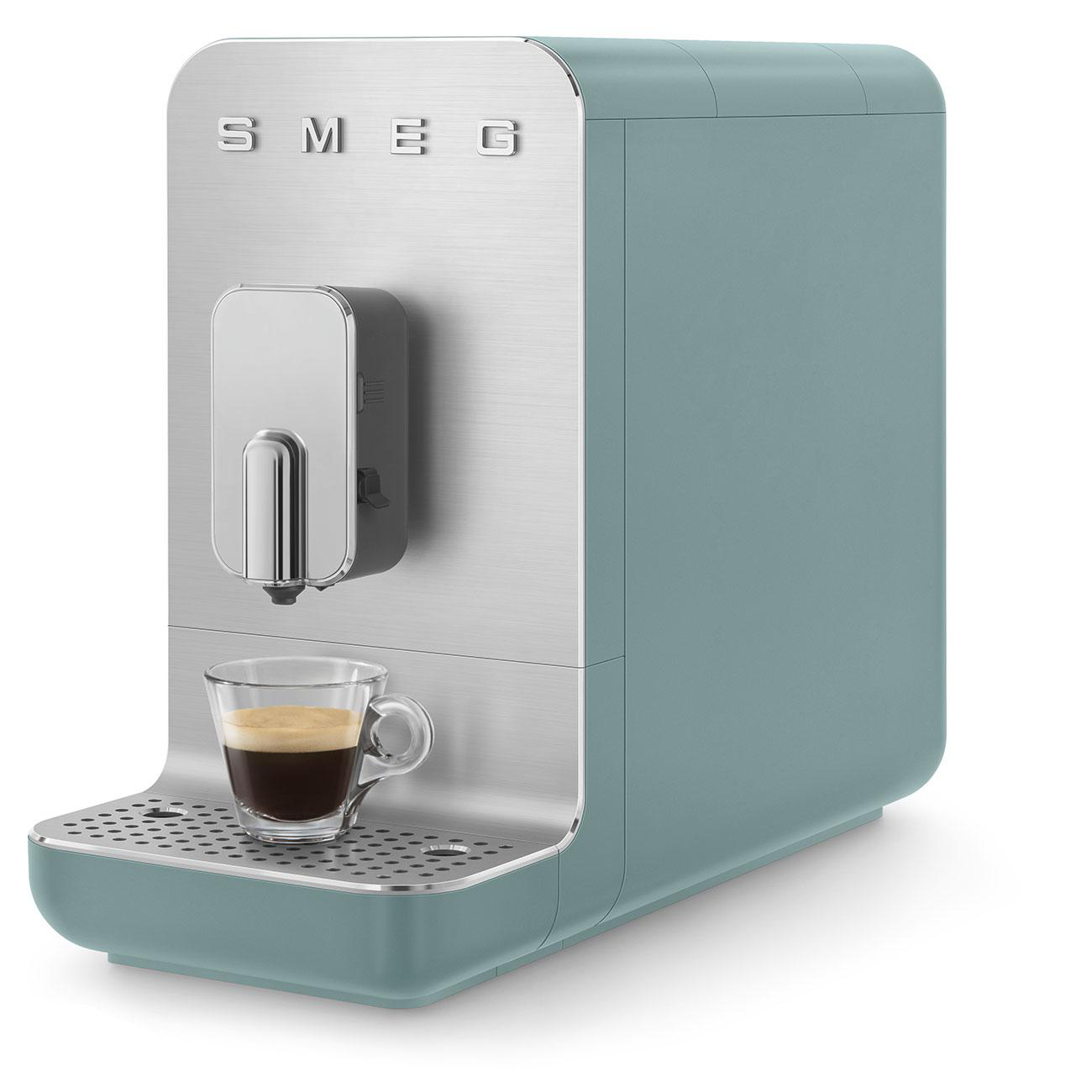Smeg Espressomaschine, mintgrün und silber, mit Tasse, auf weißem Hintergrund.