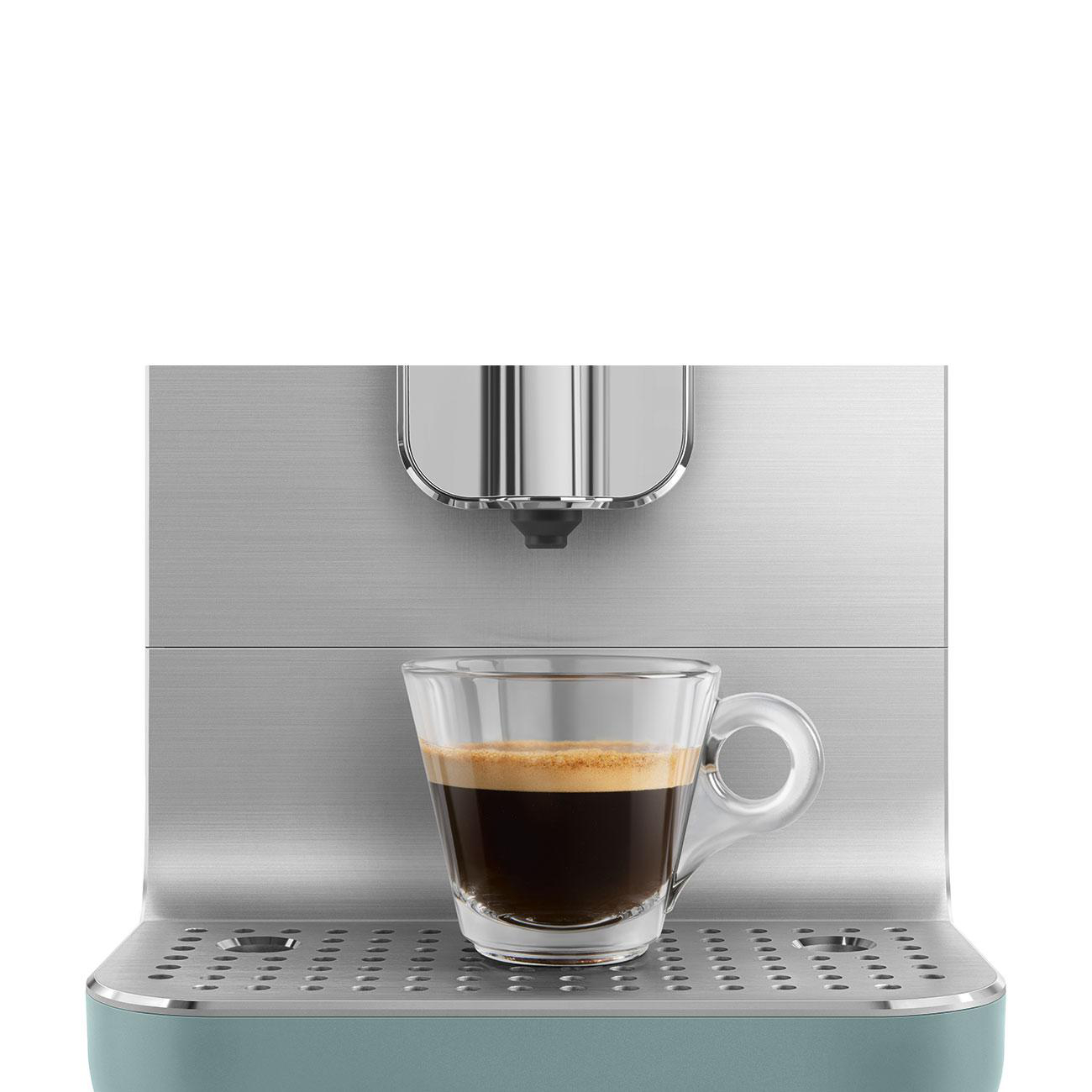 Eine Kaffeemaschine mit einer Glastasse, die Espresso enthält.
