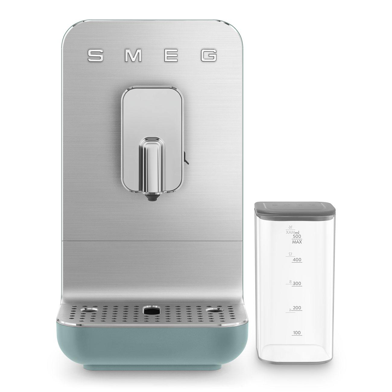 Silberne SMEG-Kaffeemaschine mit tealfarbenem Sockel neben einem durchsichtigen Wasserbehälter.