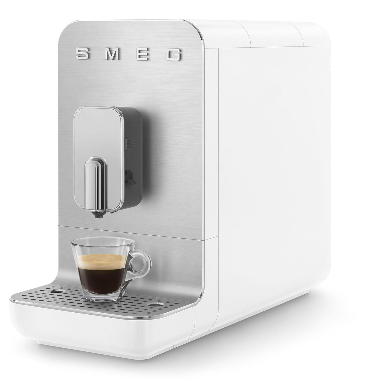 Weiße SMEG Kaffeemaschine mit Tasse und Kaffee. Edelstahl-Details.