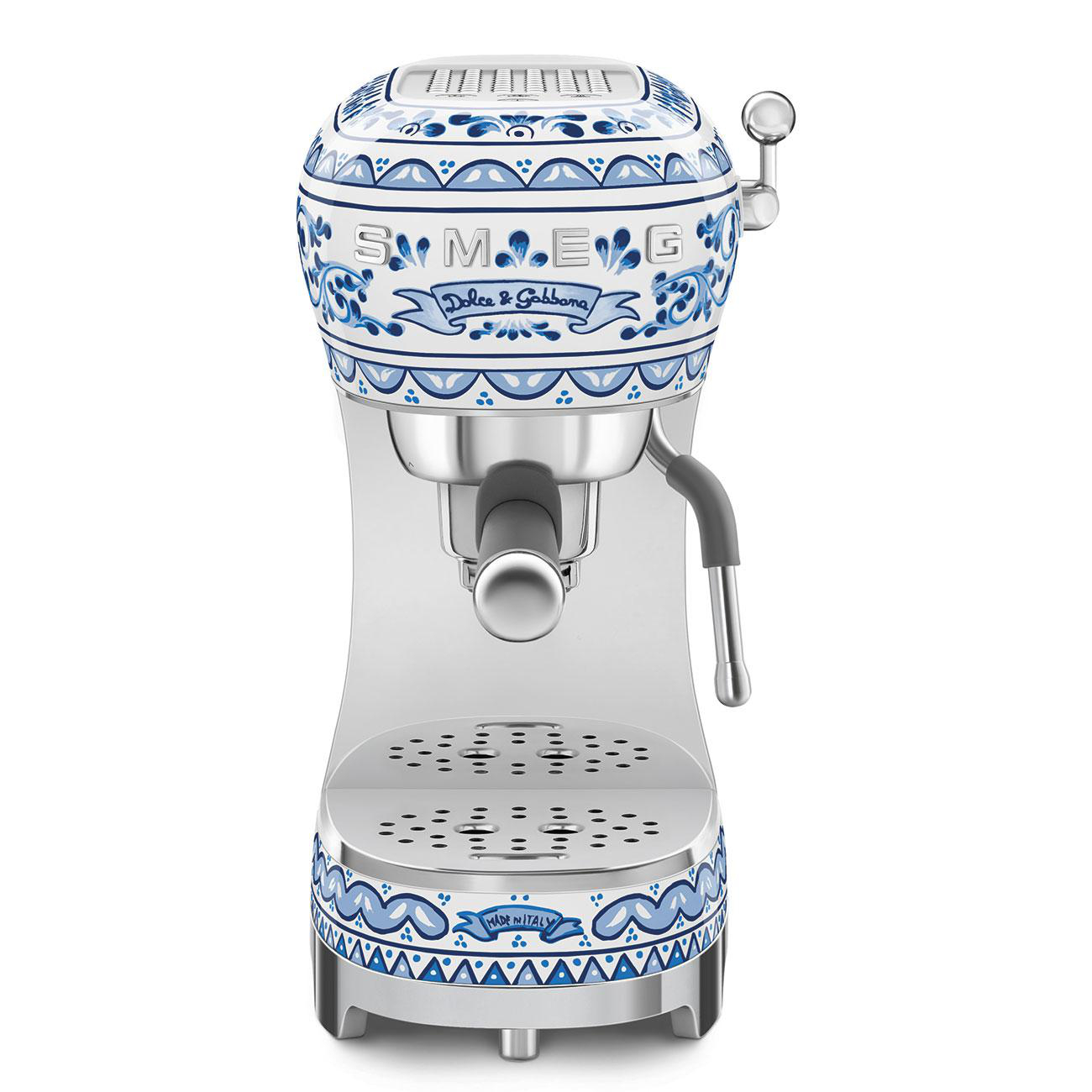 Weiß-blau gemusterte Espressomaschine. Sie hat eine silberne Abtropfschale und einen Griff.