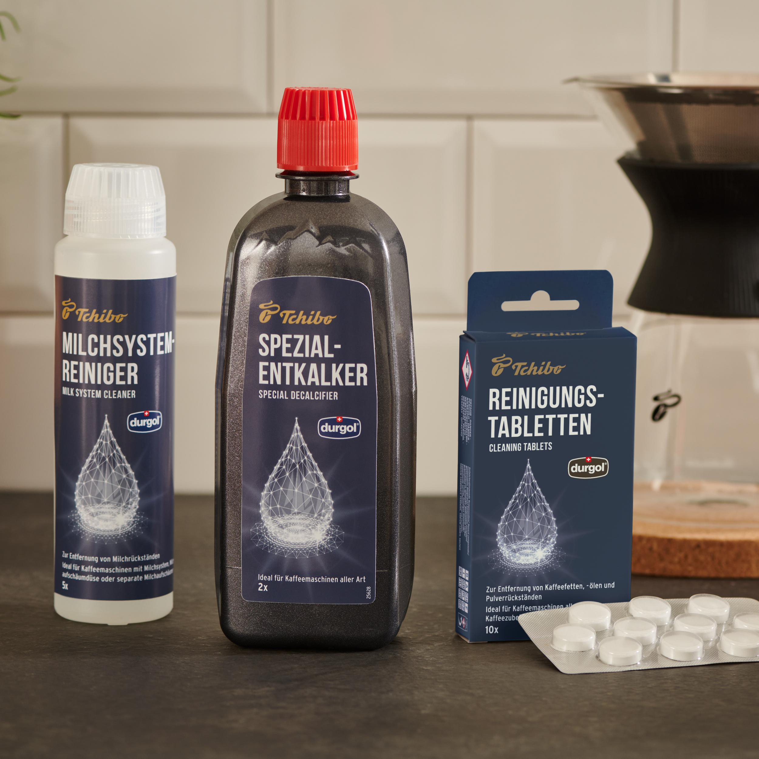 Reinigungsmittel und Tabletten für Kaffeemaschinen auf einer Theke.