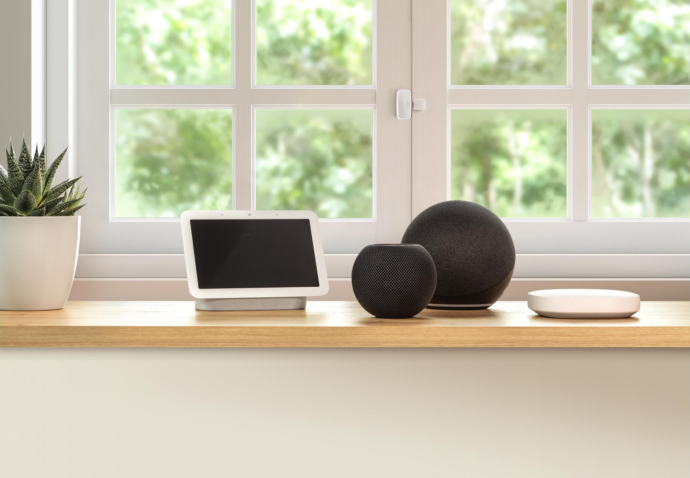 Ein Smart-Home-Setup mit Tablet, Lautsprechern und einer Pflanze.