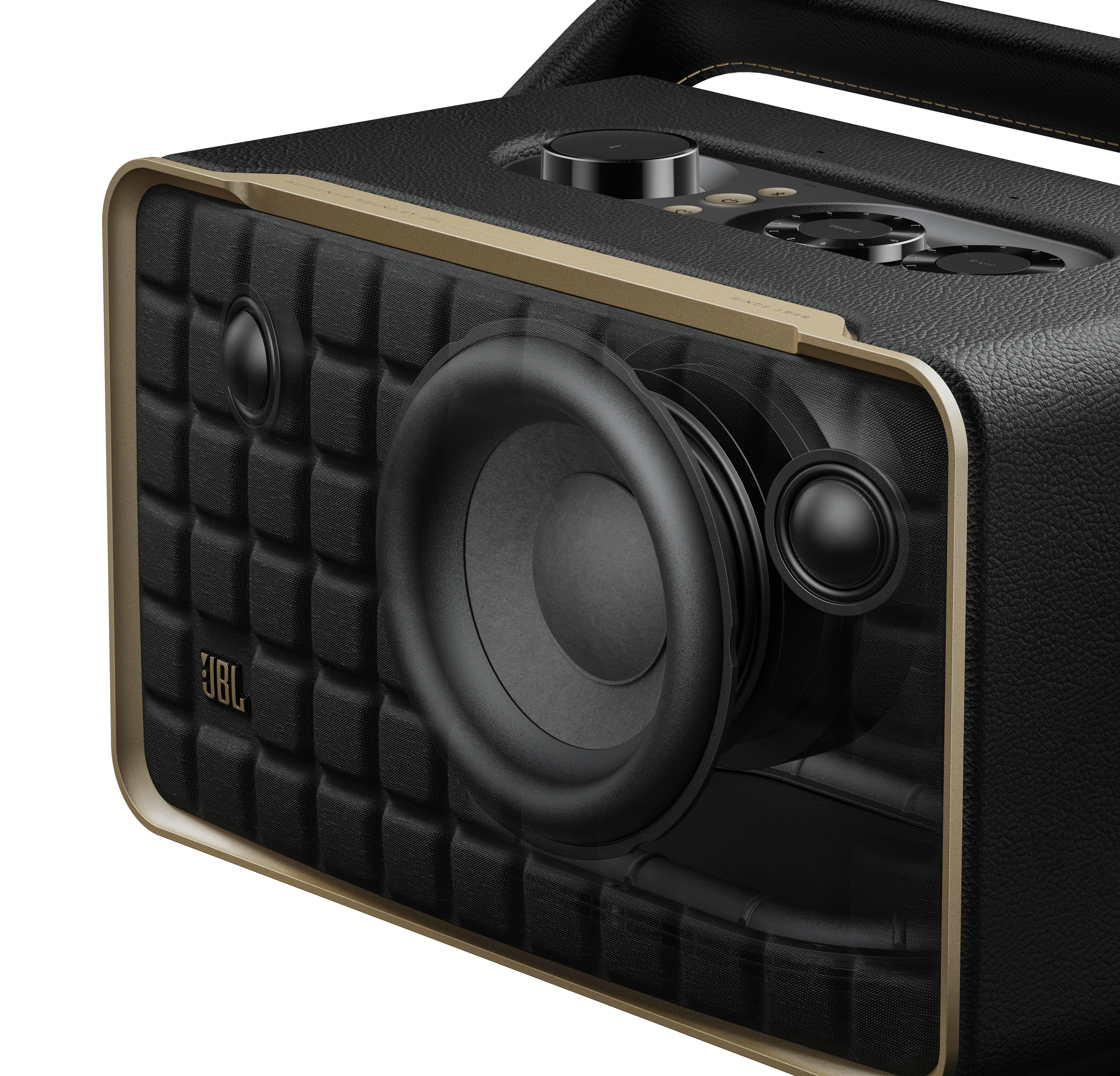 Nahaufnahme eines schwarzen JBL-Lautsprechers mit strukturierter Frontplatte und goldfarbenem Zierrat.