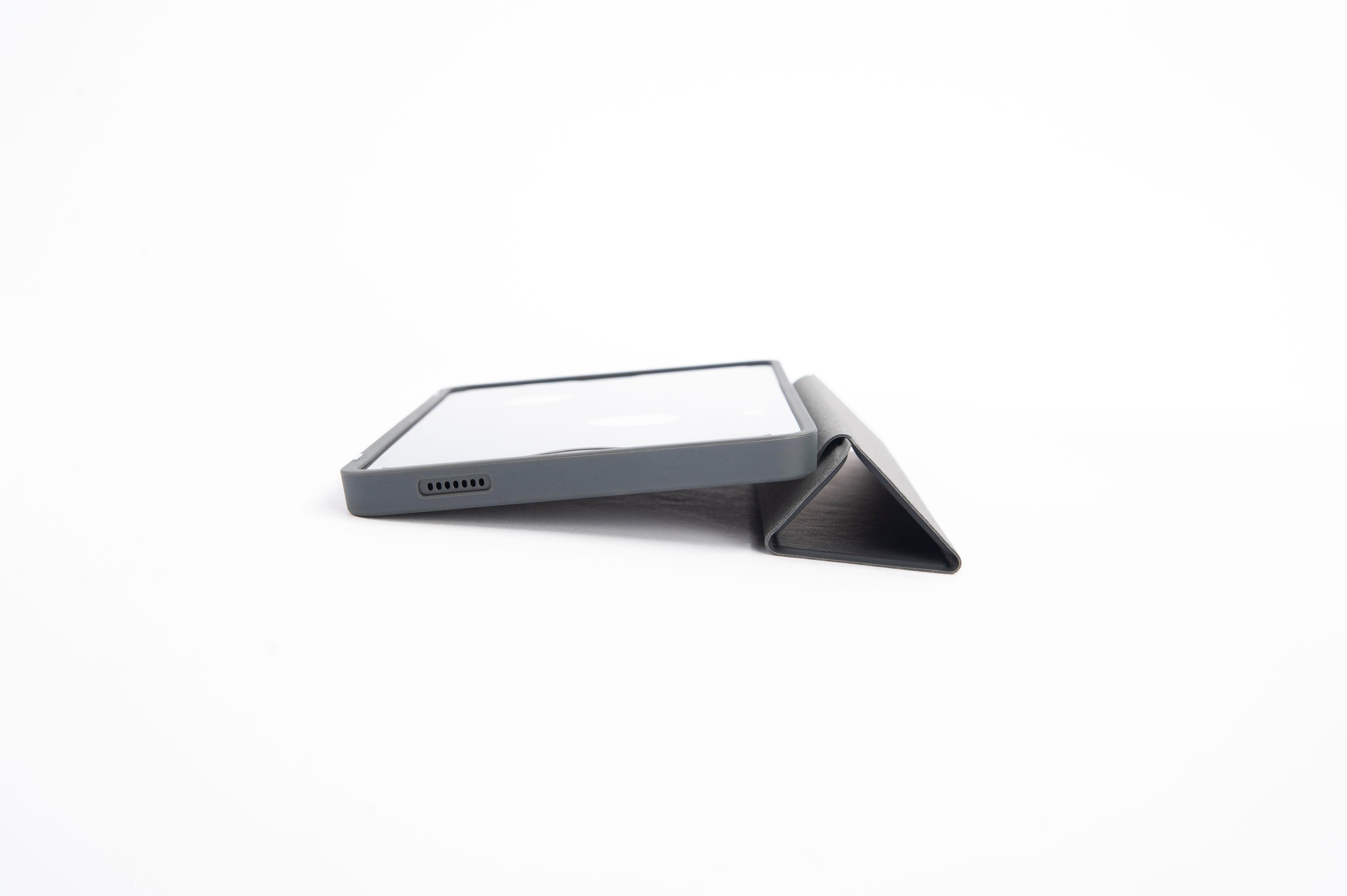 Tablet in dunklem Gehäuse, geneigt und auf einer weißen Oberfläche abgestützt.