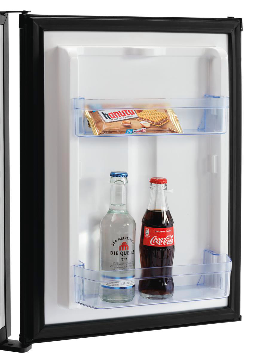 In einem Mini-Kühlschrank: eine Hanuta-Riegel, eine Wasserflasche und eine Coca-Cola-Flasche. Der Kühlschrank ist weiß mit schwarzem Rand.