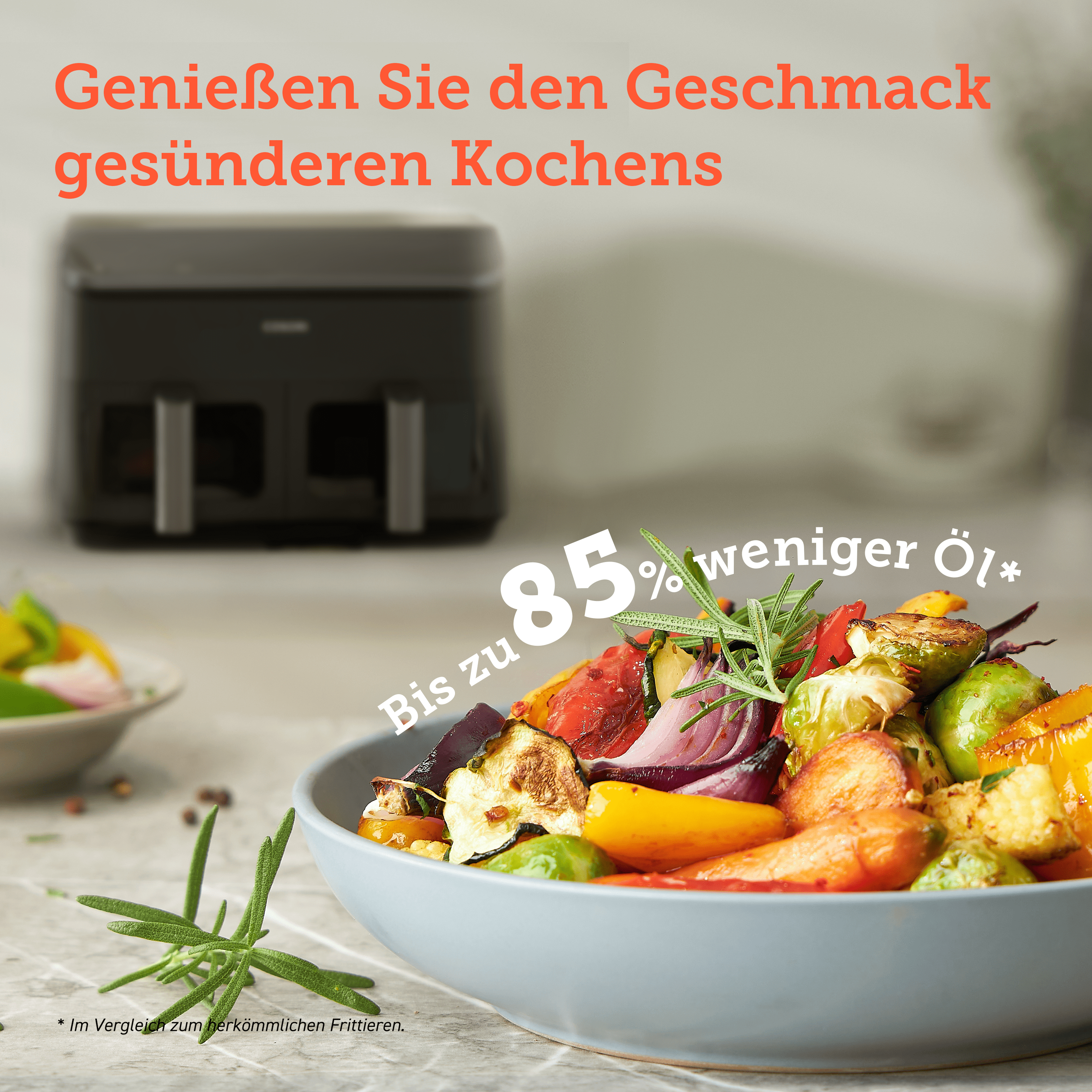Schüssel mit gebratenem Gemüse und einem schwarzen Airfryer im Hintergrund.