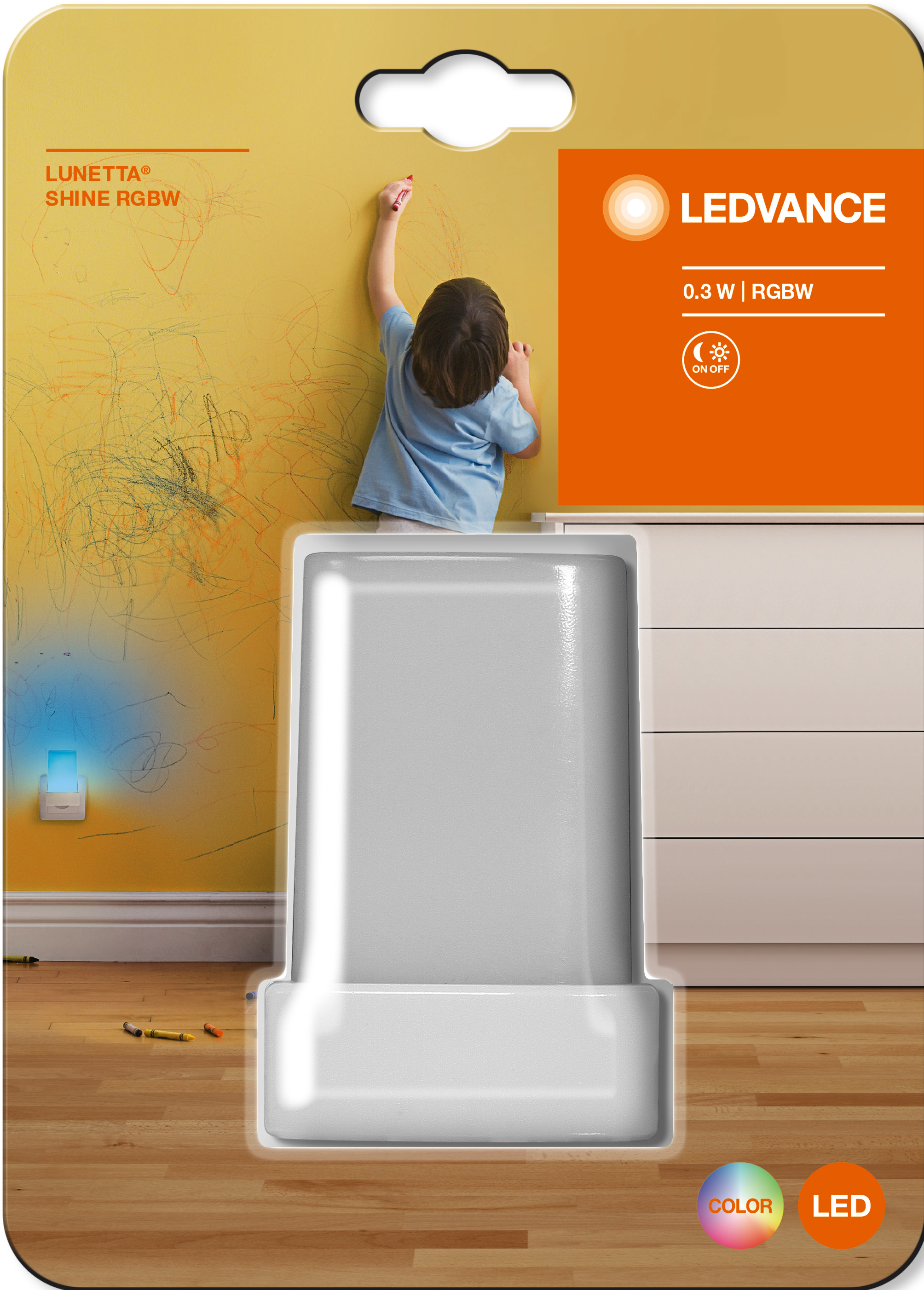 Un bambino disegna su un muro con una luce notturna in primo piano.
