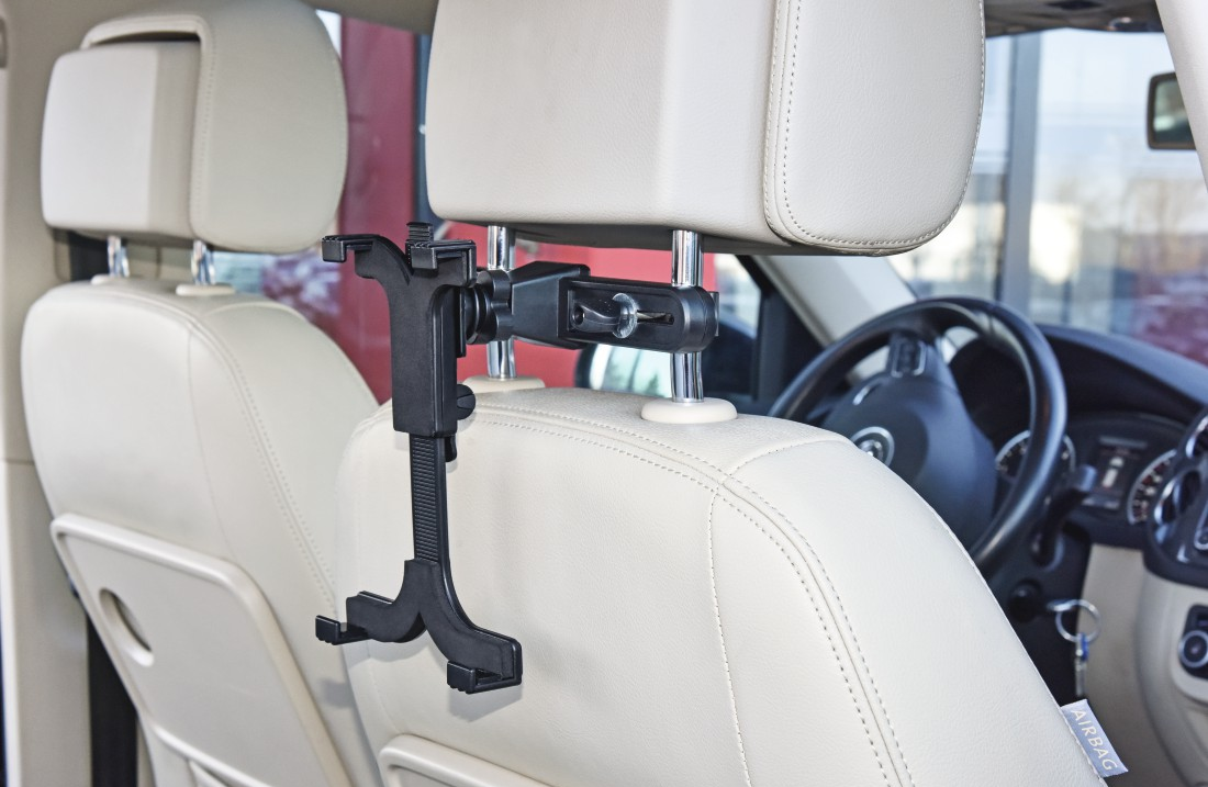Autositz mit Tablet-Halterung, der ein Tablet hält. Beige Innenausstattung.