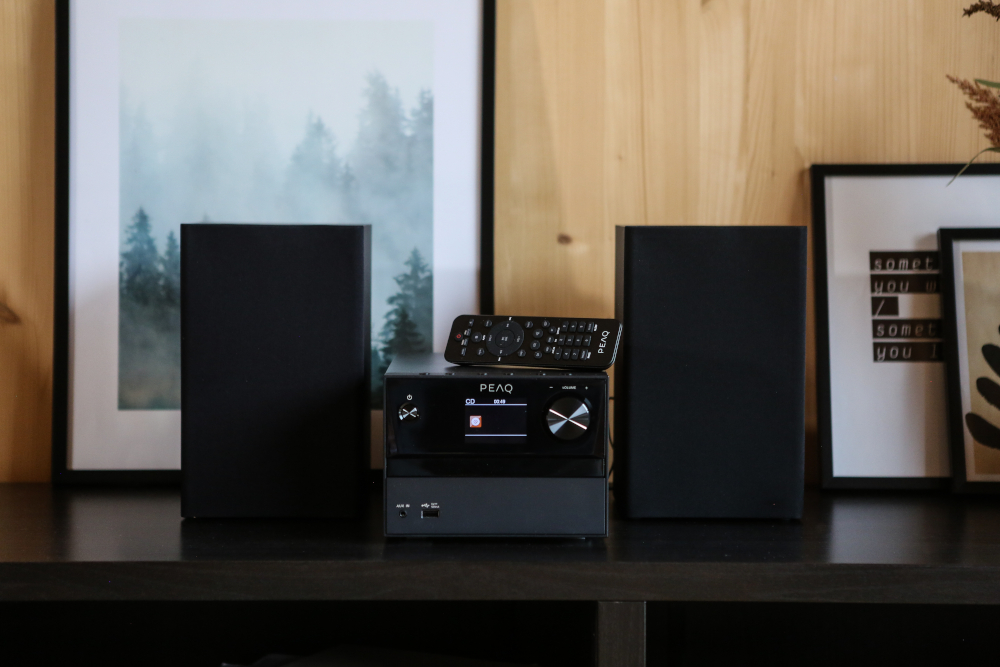 Audiosysteem met speakers, afstandsbediening en zwarte componenten.