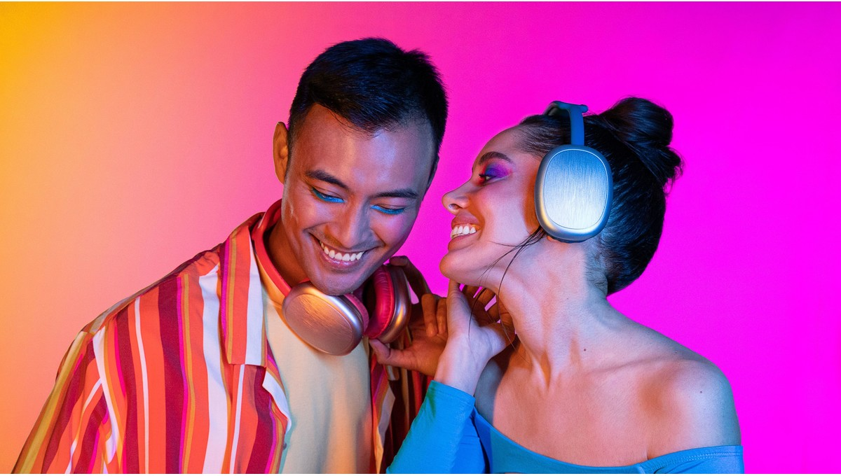 Deux personnes souriantes, une avec une chemise rayée, portant un casque.