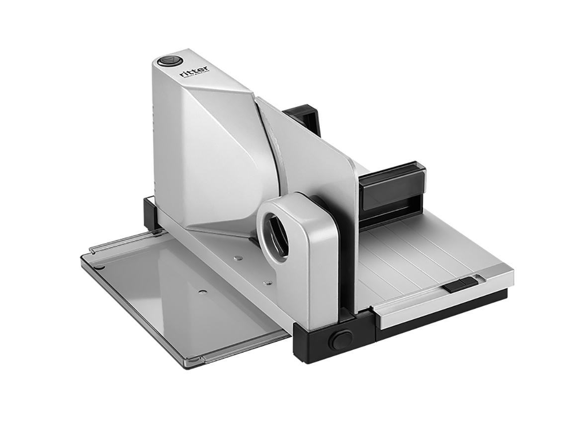 Silberne Fleischschneidemaschine mit schwarzem Knopf, auf weißer Oberfläche. Markenname sichtbar.