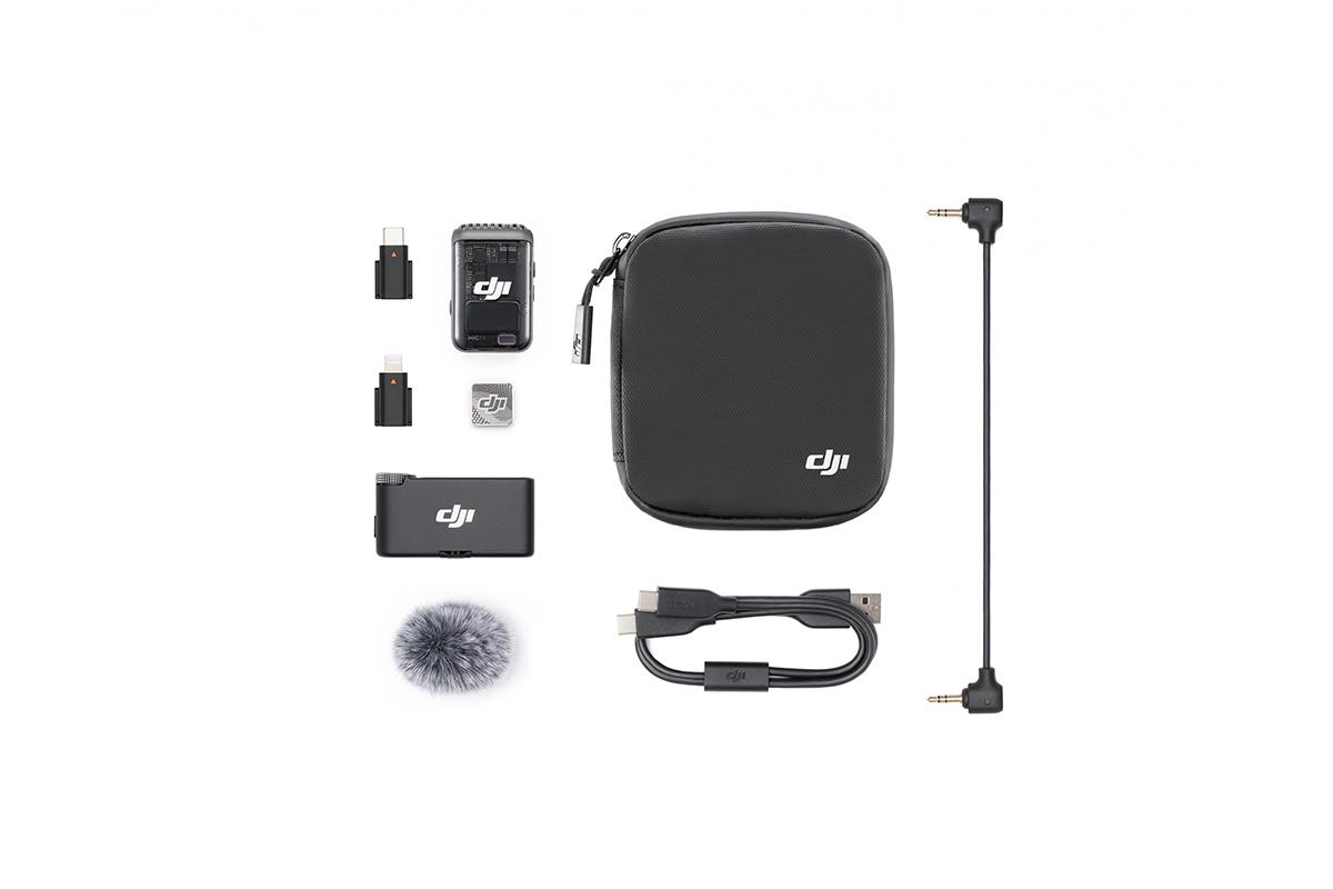 DJI drahtloses Mikrofon-Kit mit mehreren Komponenten, darunter Sender, Empfänger und Ladekoffer, auf einer Oberfläche angeordnet.