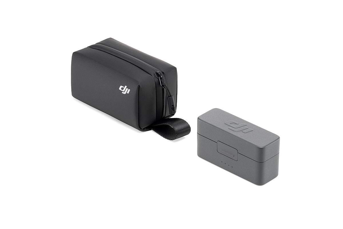 Eine schwarze Reißverschlusstasche und eine graue Box, beide mit Logo, auf weißem Grund.