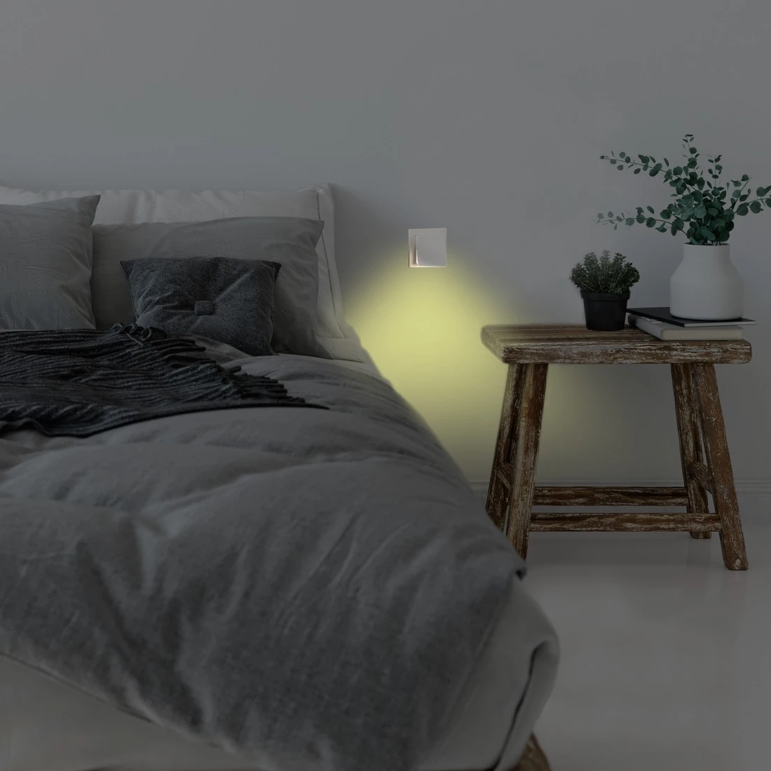 Camera da letto di notte con letto, lampada a muro, comodino e piante.
