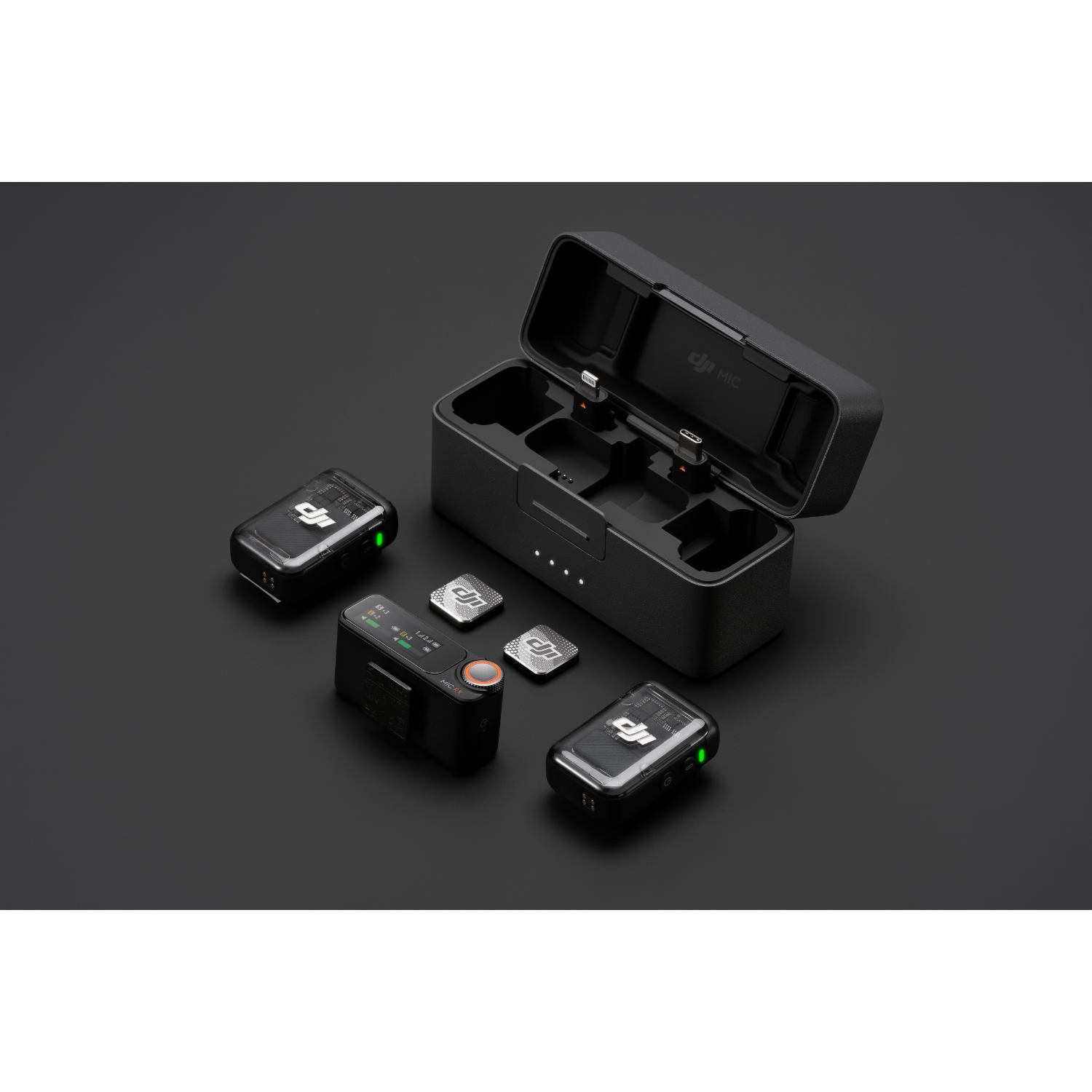 DJI Mic set. Microfoon, ontvanger, oplaadcase. Zwarte achtergrond. Draadloze audio-apparatuur.