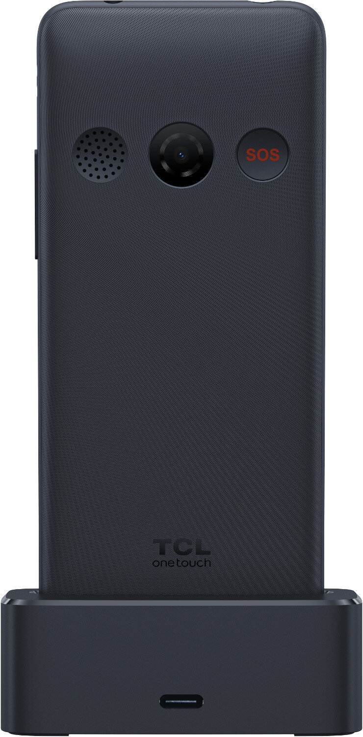 Ciemnoniebieski telefon z klapką z czarną podstawą. Posiada kamerę, przycisk SOS i logo TCL.