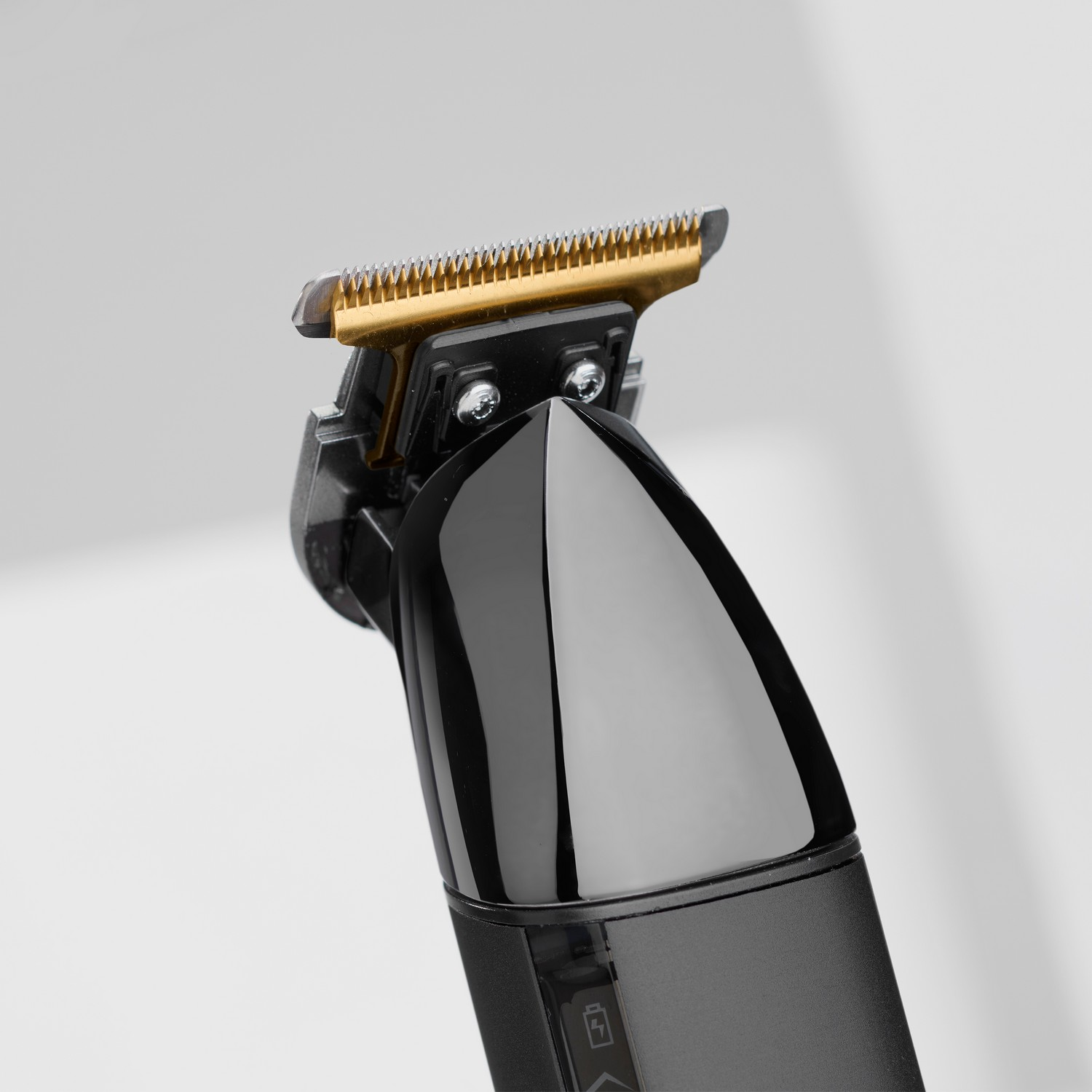 Black and gold hair trimmer, close-up view of the blade.