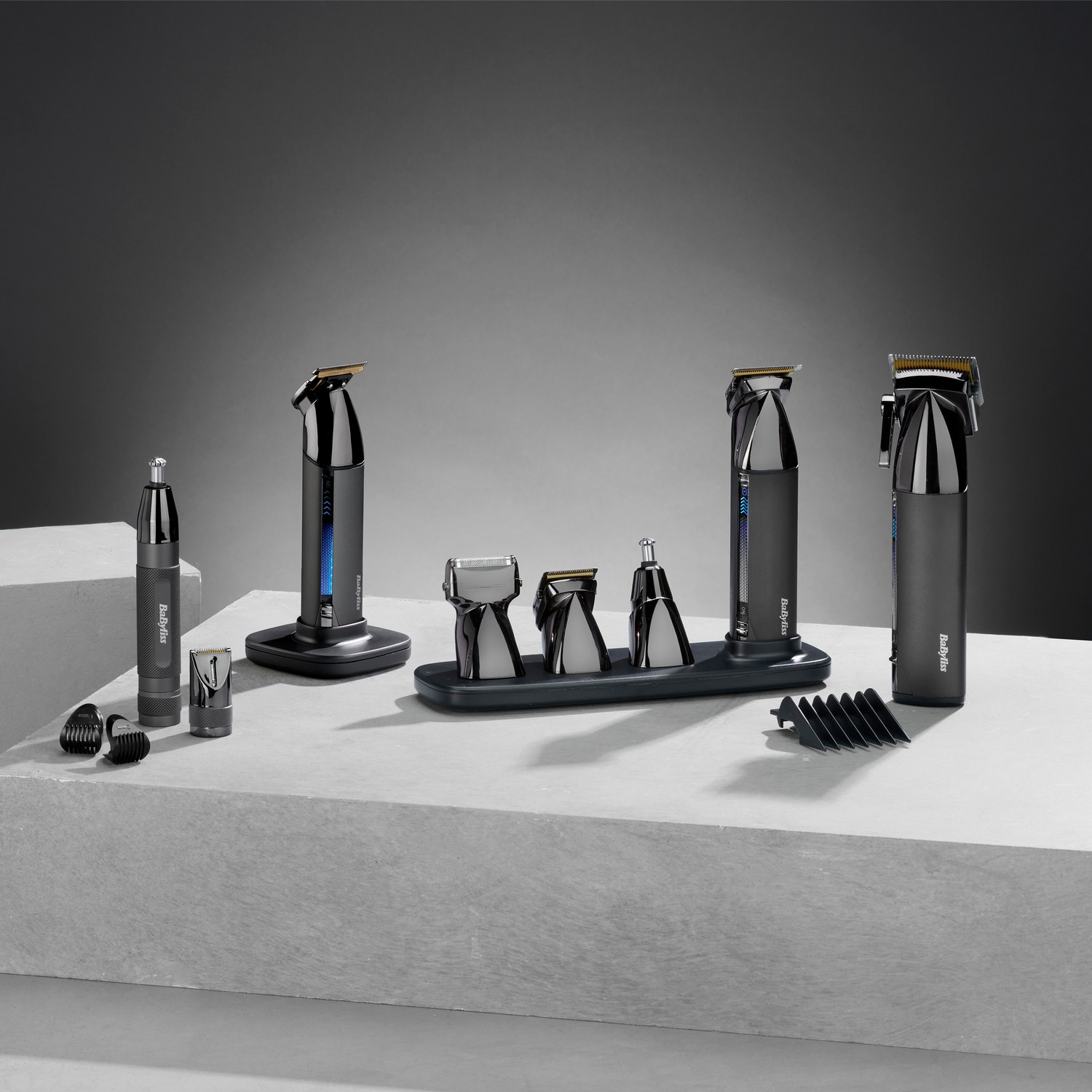 A display of grooming devices on a gray surface. A dark gray background.