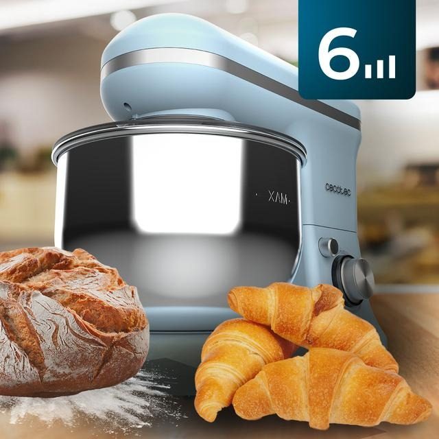 Batidora azul con pan y cruasanes sobre una superficie de madera.