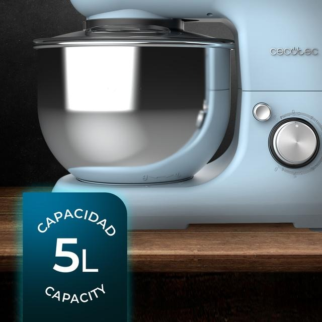 Procesador de alimentos azul claro con cuenco plateado sobre madera.