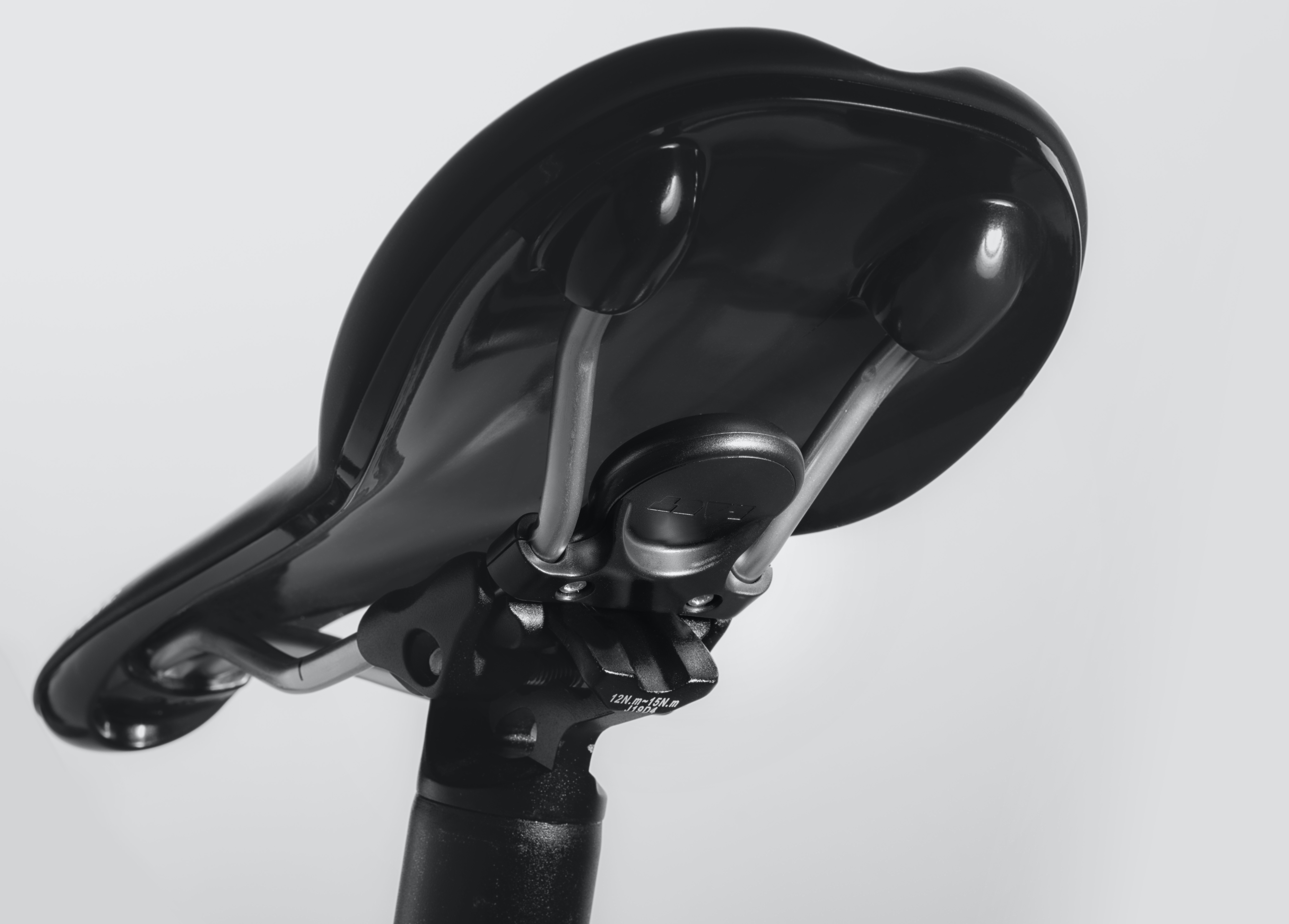 Selle de vélo noire avec rails argentés sur fond clair.
