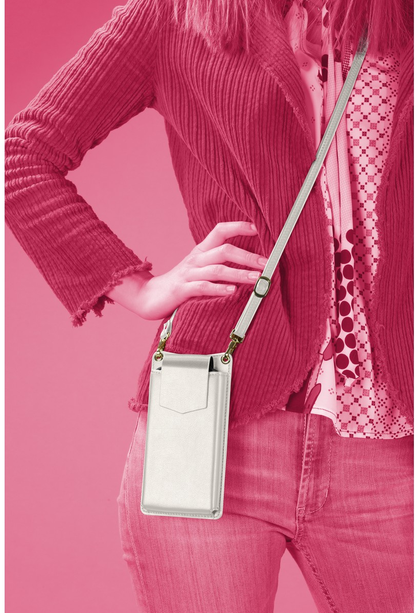 Femme en tenue rose tenant un étui de téléphone argenté avec une sangle.