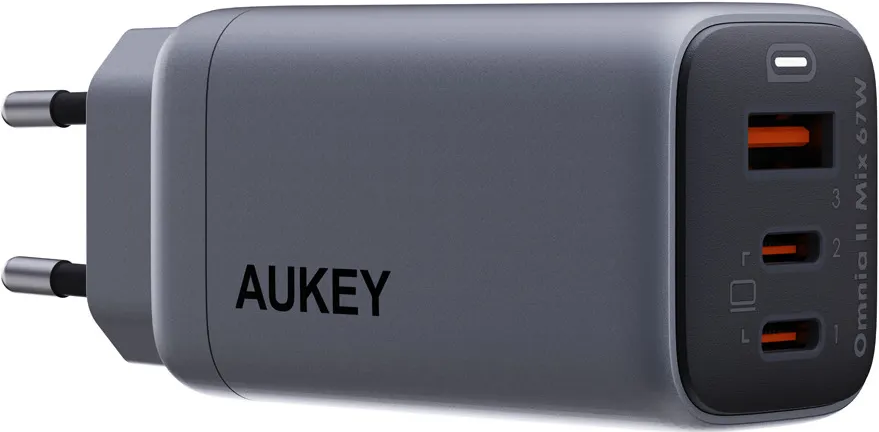 Graues AUKEY-Ladegerät mit drei orangefarbenen USB-Anschlüssen. Zwei Stifte sind für den Stecker sichtbar.