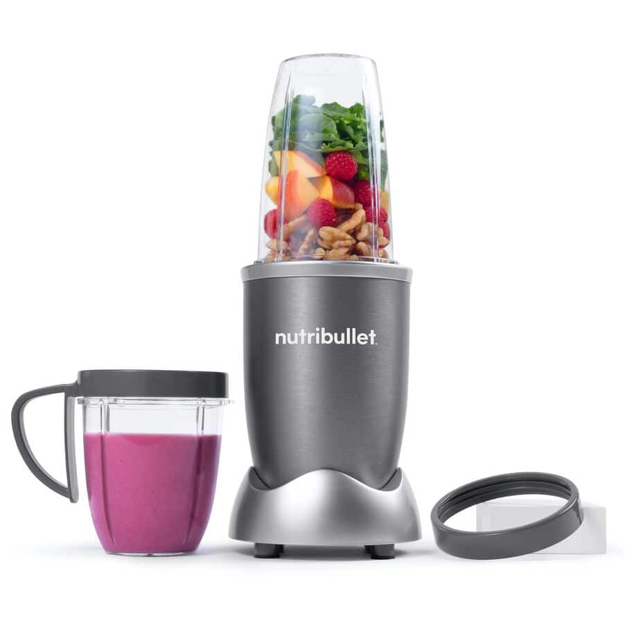 NutriBullet turmixgép hozzávalókkal, plusz egy csésze rózsaszín folyadékkal.