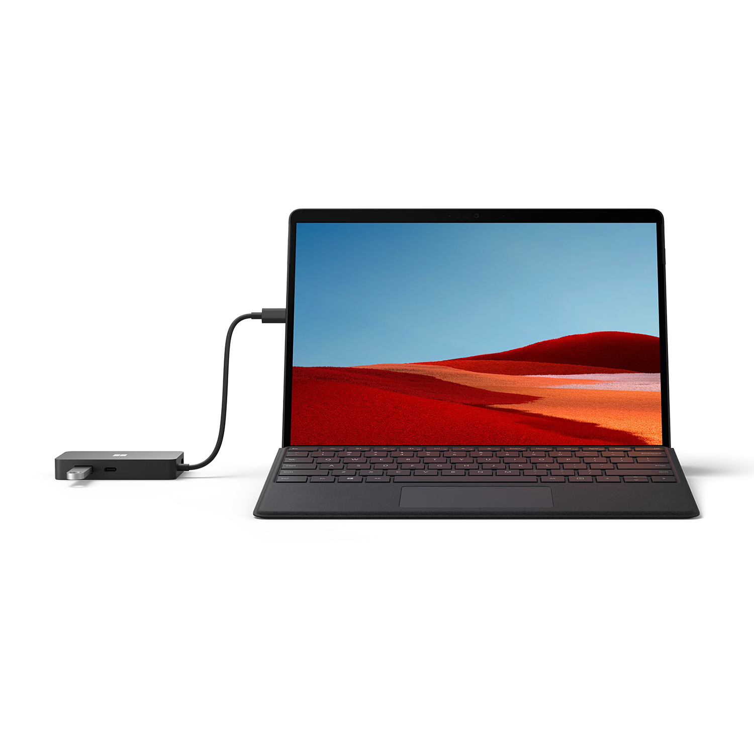 Un laptop nero collegato a un hub nero tramite un cavo. Lo schermo mostra un paesaggio. Sfondo bianco.