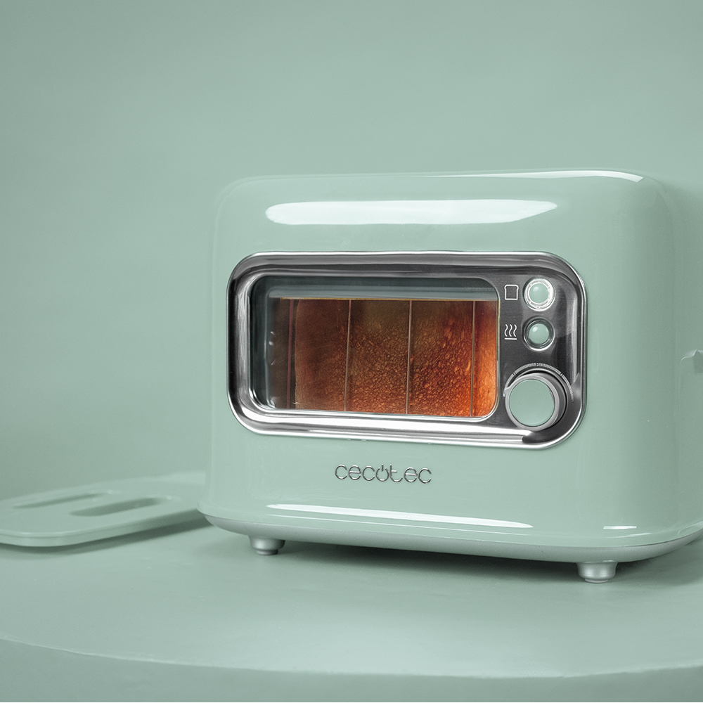 Tostadora verde menta de estilo retro con una ventana que muestra la tostada. Una bandeja se encuentra a la izquierda.